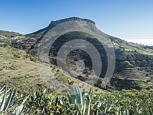 View on table mountain Fortaleza with surraunding villages Chipude and Pavon and Agave succulent plant leaves. Blue sky