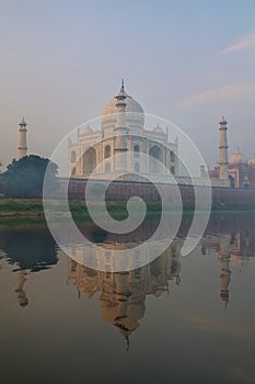 View of Taj Mahal with early morning fog reflected in Yamuna Riv