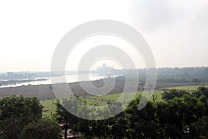 The view of Taj Mahal by the river as seen from Agra Fort