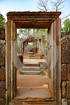 View through temple entrance in ruins of Banteay Srei, Cambodia, to the green forest.