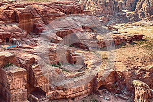 View of temples carved into sandstone rocks at daytime in Siq Gorge, Petra, Jordan.