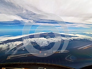 A view of Tenerife island and volcano Teide from the cockpit of ATR-72, the island surrounded by clouds, Canary Islands, Spain