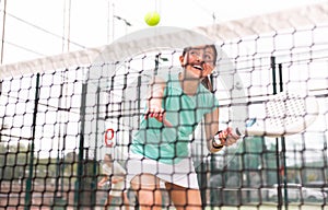 View through tennis net of an female playing padel