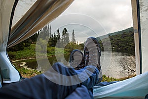 View from tent on a mountain lake. Trips and expeditions in the wild. Concept of camping