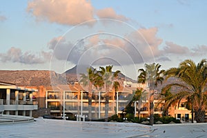 View from terrace of hotel on the palm trees and swimming pool in Holiday resort TUI Magic Life during sunrise.