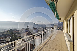 View from a terrace of a top floor apartment. You can see the town below and the mountains in the distance