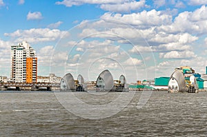 View of the Thames Barrier on a cloudy day under blue sky in London.