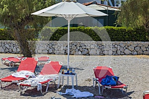 View of things and shoes of tourists left on sun loungers on beach. Greece. .