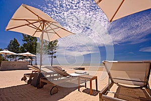 View of three chairs and umbrella on the beach