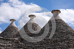 View of three conical dry stone roofs of a traditional trullo dry stone houses in Alberobello in Puglia Italy.