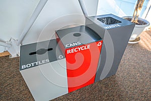 View of three trash bins with bottles, cans, and waste signs- Tucson, Arizona