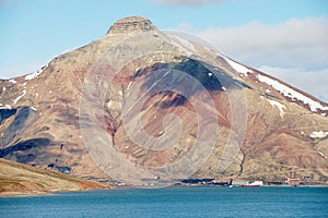 View to the abandoned Russian arctic settlement Pyramiden with the natural mountain in the form of pyramid above, Norway.