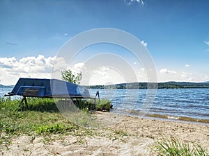 View to anchored laminate blue rowing boat at large lake