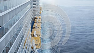 view to the back aft of the cruise ship from front deck area with side view of the passenger cruise ship while cruising in the sea