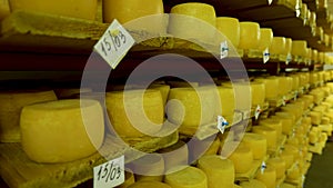 View to the cheese-wheels of parmesan maturing on the shelves at the cellar of the cheese factory
