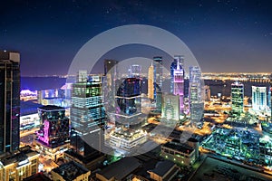 View to the city center of Doha by night with starry sky