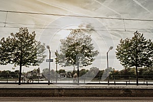 View to the city and  green park on a sunny cloudy fall day with clouds and an elderly unrecognisable man, film effect