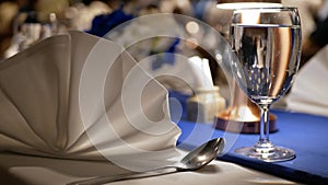 view to the classy banquet table for celebration at banquet hall in night time with well prepared setting napkin for dinner time