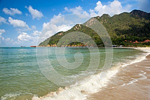 View to the empty tropical island beach under waves