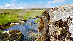 A view to English landscape with blurred backspace with brook stones under blue sky and clouds