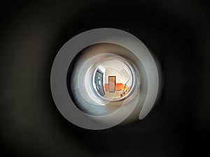 View to the hall through peephole eyelet in the door.