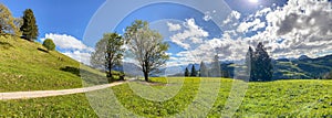 View to Inntal and Wilder Kaiser mountain range in the Alps, Building land for new construction project on green sunny meadow, photo