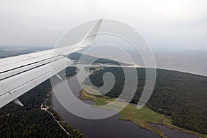 View to the Jurmala National Park under flying airplane wing