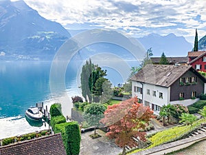 view to lake Urner with old houses and motorboat at the coast in Bauen, Switzerland photo