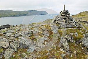 View to the Mageroya Cape and sea with the stack of stones at the fore ground in North Cape, norway.