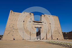 View to the main entrance of an Ancient Egyptian Edfu Temple showing the first pylon in the Sunny Day
