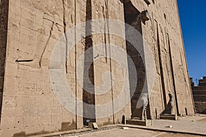 View to the main entrance of an Ancient Egyptian Edfu Temple showing the first pylon in the Sunny Day