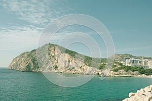 View to Mediterranean Sea, rocky shores, nature arround La Cala Villajoyosa with modern apartment buildings skyscrapers