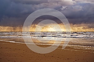 View to the ocean at sunset. Cloudy sky and illuminated horizon. North Holland dune reserve, Egmond aan Zee, Netherlands