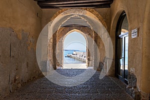 View to the old harbour and beach from Porta Pescara fishermen`s gate on a sunny day in Cefalu, Sicily, Southern Italy