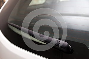 View to the rear window wiper that remove the melted snow and dirt from the windshield of the car during the day during the snow