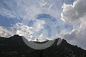 Pohľad na skalnaté hory proti zamračenej oblohe vo Vysokých Tatrách (Vysoke Tatry), Slovensko