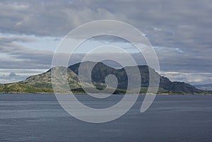 View to the sea and mountains in Torget island in BrÃ¸nnÃ¸y, Nordland on summer evening