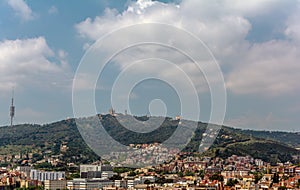 View to the Tibidabo mountain with Sagrat Cor church and Amusement Park atop. The Torre de Collserola telecommunications tower is