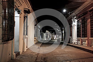 View to typical street with one story buildings at night in light of lanterns, Santa Cruz de Mompox, Colombia, World Heritage