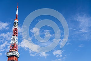 View of Tokyo tower with blue sky and airplane with cloud condensation trails in the background with copy space in Japan winter