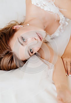 View top. bride in white dress lying in bed
