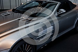 View from the top on front and side of modern grey cabriolet car with mirror, windshield wipers and light alloy wheels