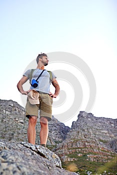 The view from the top. a handsome young man enjoying the view while hiking.