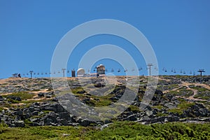 View at the top of the mountains of the Serra da Estrela natural park, tower buildings with dome and cable car railway circuit,