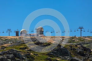 View at the top of the mountains of the Serra da Estrela natural park, tower buildings with dome and cable car railway circuit,