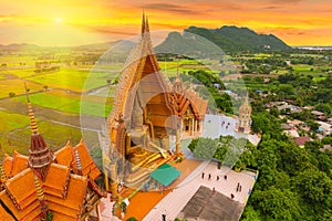 A view from the top of the pagoda, golden buddha statue with rice fields and mountain, Tiger Cave Temple (Wat Tham Seua) Thai and