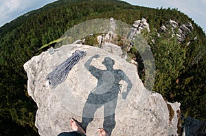 View from top of rock with shadow in power pose.