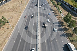 View from the top to the highway. Aerial drone shooting of a multi-lane road with moving vehicles. Car traffic in a big