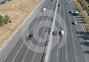 View from the top to the highway. Aerial drone shooting of a multi-lane road with moving vehicles. Car traffic in a big