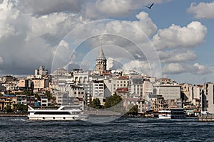 View of tour boats on Golden Horn area of Bosphorus in Istanbul. Galata tower and Beyoglu district are in the background.